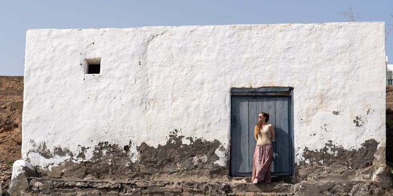 Jessica Burgada, fondatrice d'Archipel Brut, devant une maison traditionnelle canarienne à la façade blanchie à la chaux